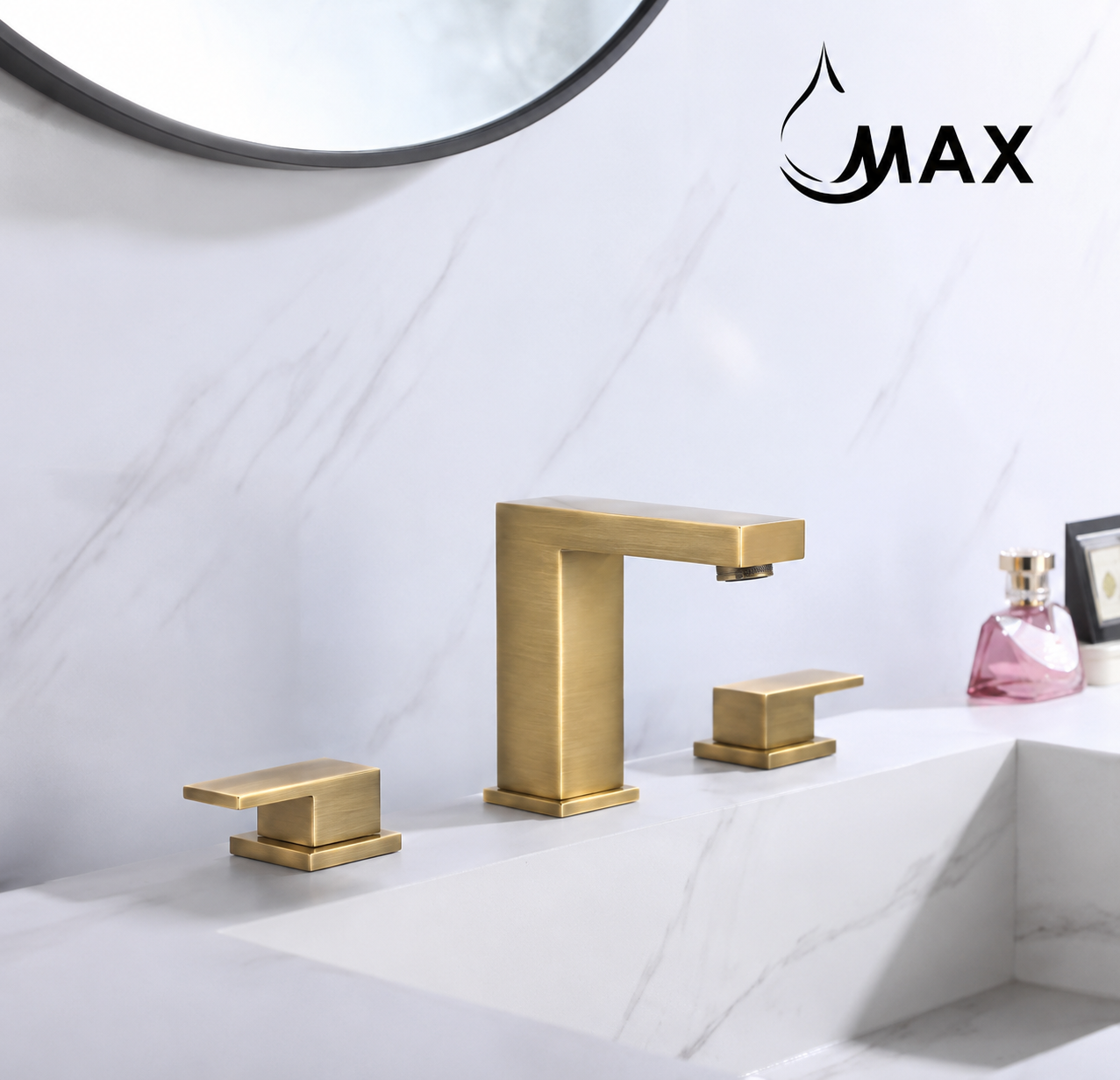 A modern three-hole bathroom faucet set in brushed gold with matching handles, installed on a white marble sink. A round mirror is partially visible at the top, and a pink perfume bottle sits on the counter.