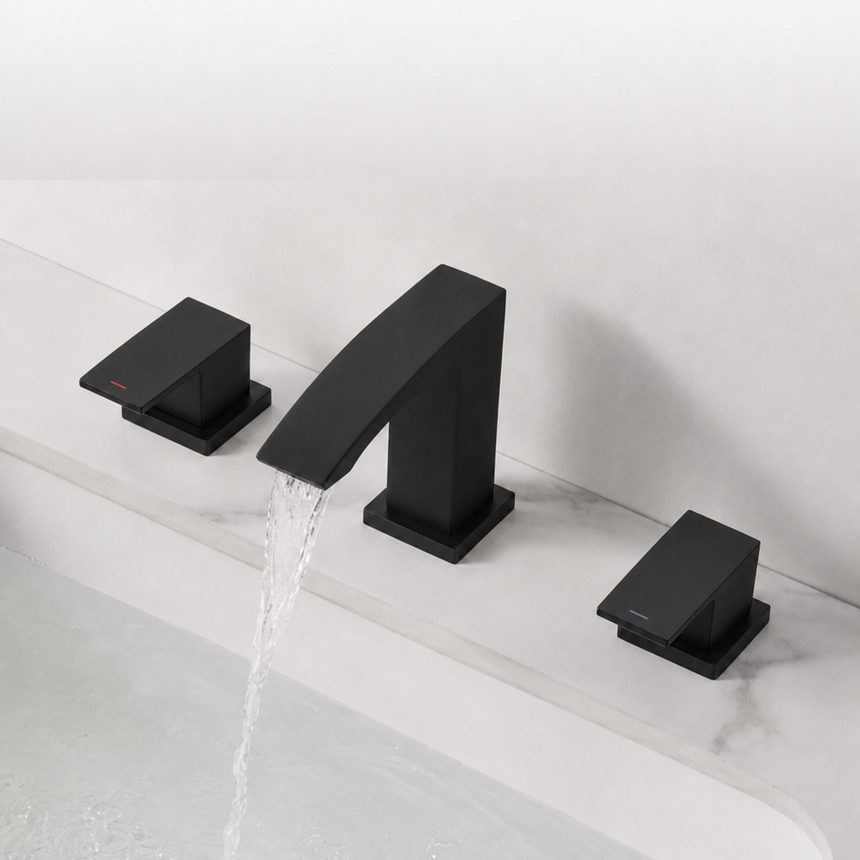 Three-piece matte black bathroom faucet set with two handles and a curved spout, shown installed on a white marble sink with water flowing from the tap.