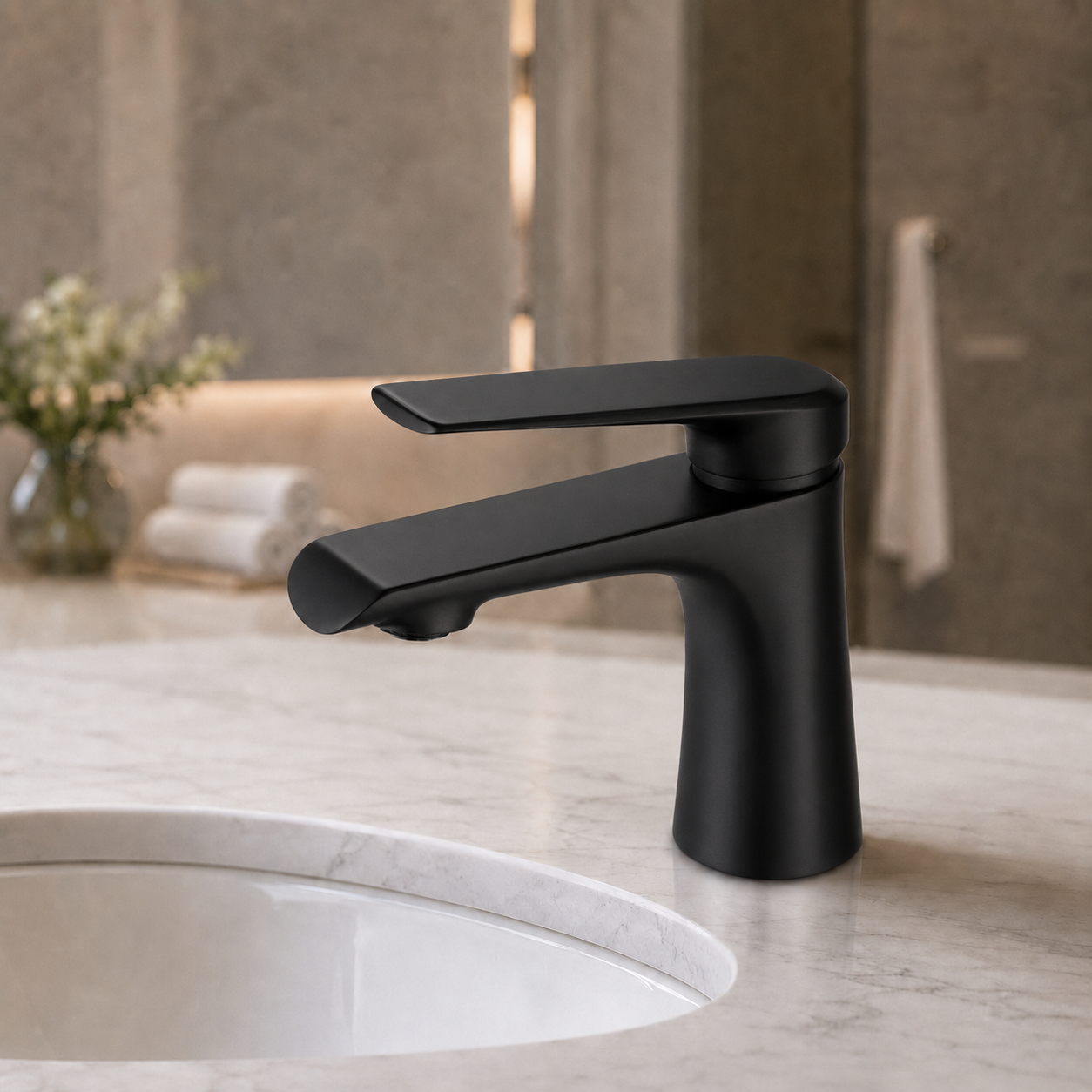 Matte black single-handle bathroom faucet installed on a light marble countertop with a white sink basin, shown in a softly blurred bathroom setting.