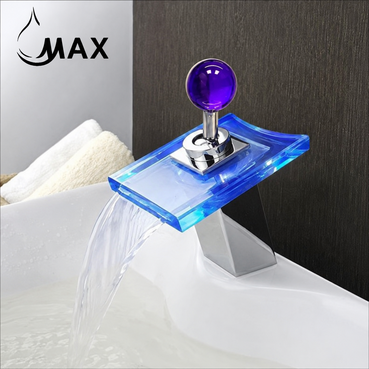 A modern waterfall bathroom faucet with a translucent blue acrylic tray, a polished chrome base, and a spherical purple knob, shown installed above a white sink with water flowing out. The word 'MAX' appears in the upper left corner.