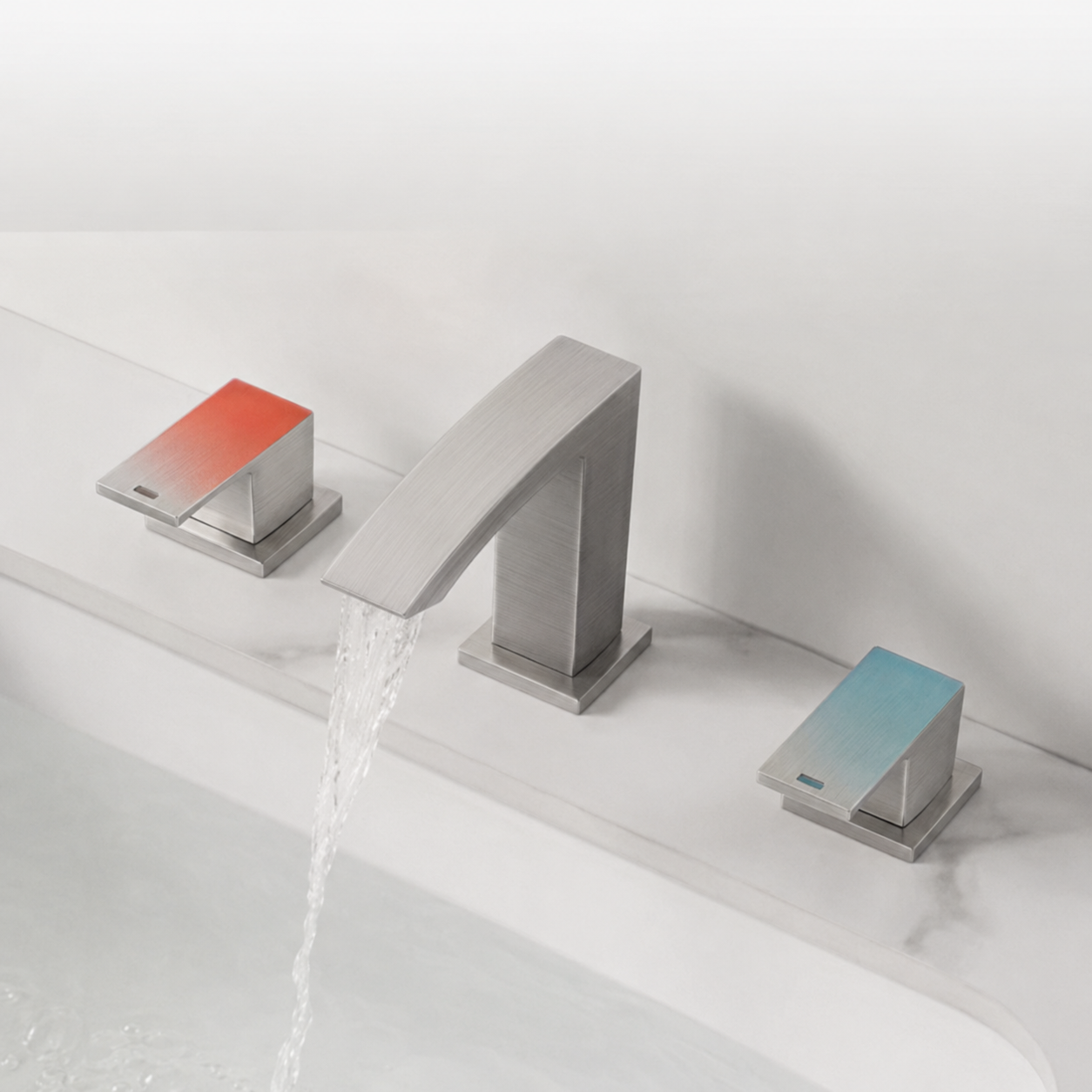 A modern three-hole bathroom faucet set with a brushed silver central spout and two flat lever handles, one showing a red-to-orange gradient and the other a blue-to-teal gradient, installed on a white sink with water flowing from the spout.
