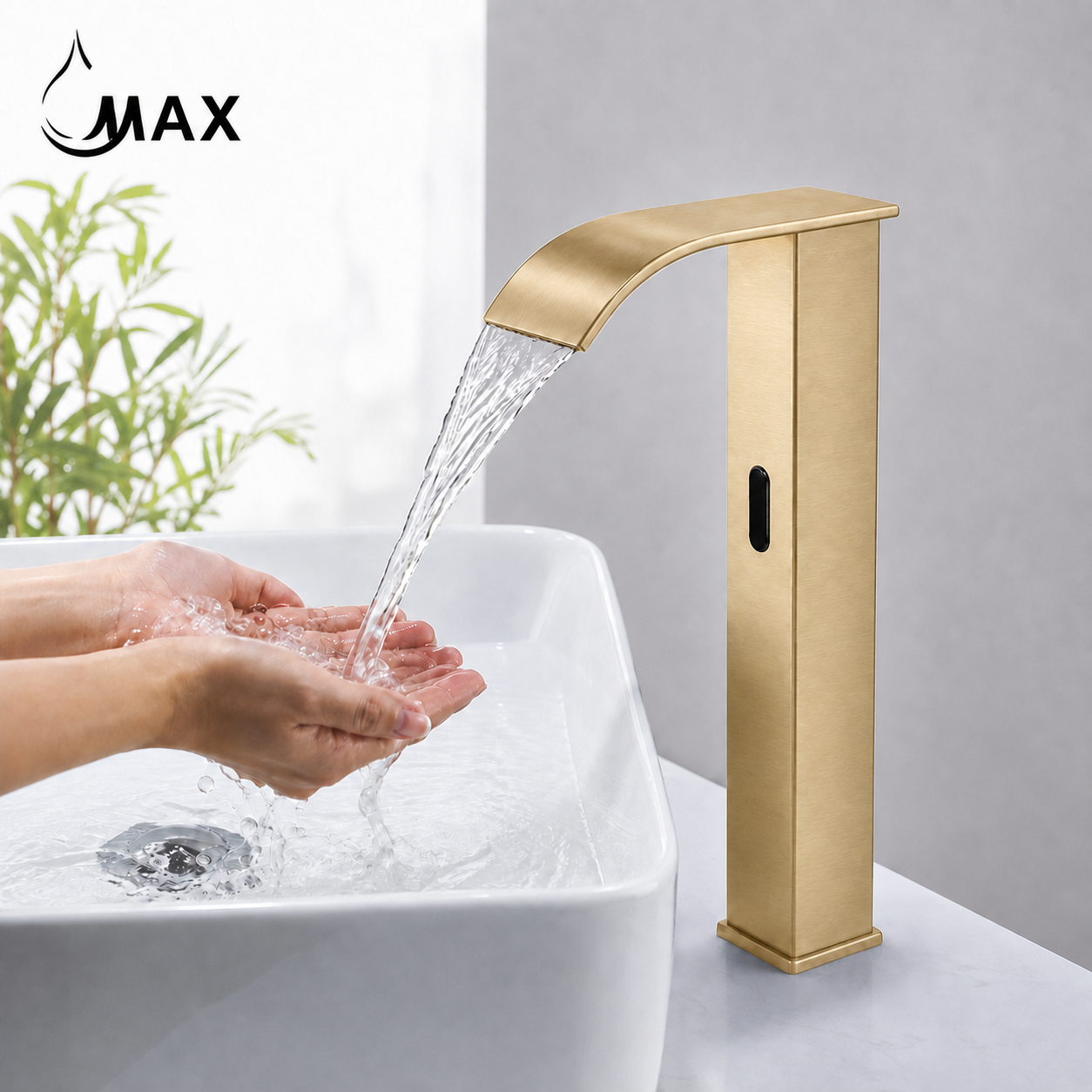 A modern tall faucet in brushed gold metal shown next to a white vessel sink. The faucet has a curved spout, a vertical body with a small black oval detail, and is set against a gray wall background.