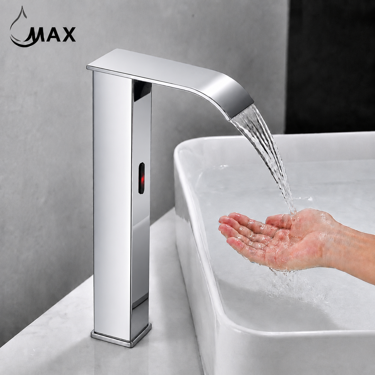 A modern chrome single-lever faucet with a waterfall spout mounted beside a white sink, with water flowing into a hand. The brand name 'MAX' appears in the top left corner.
