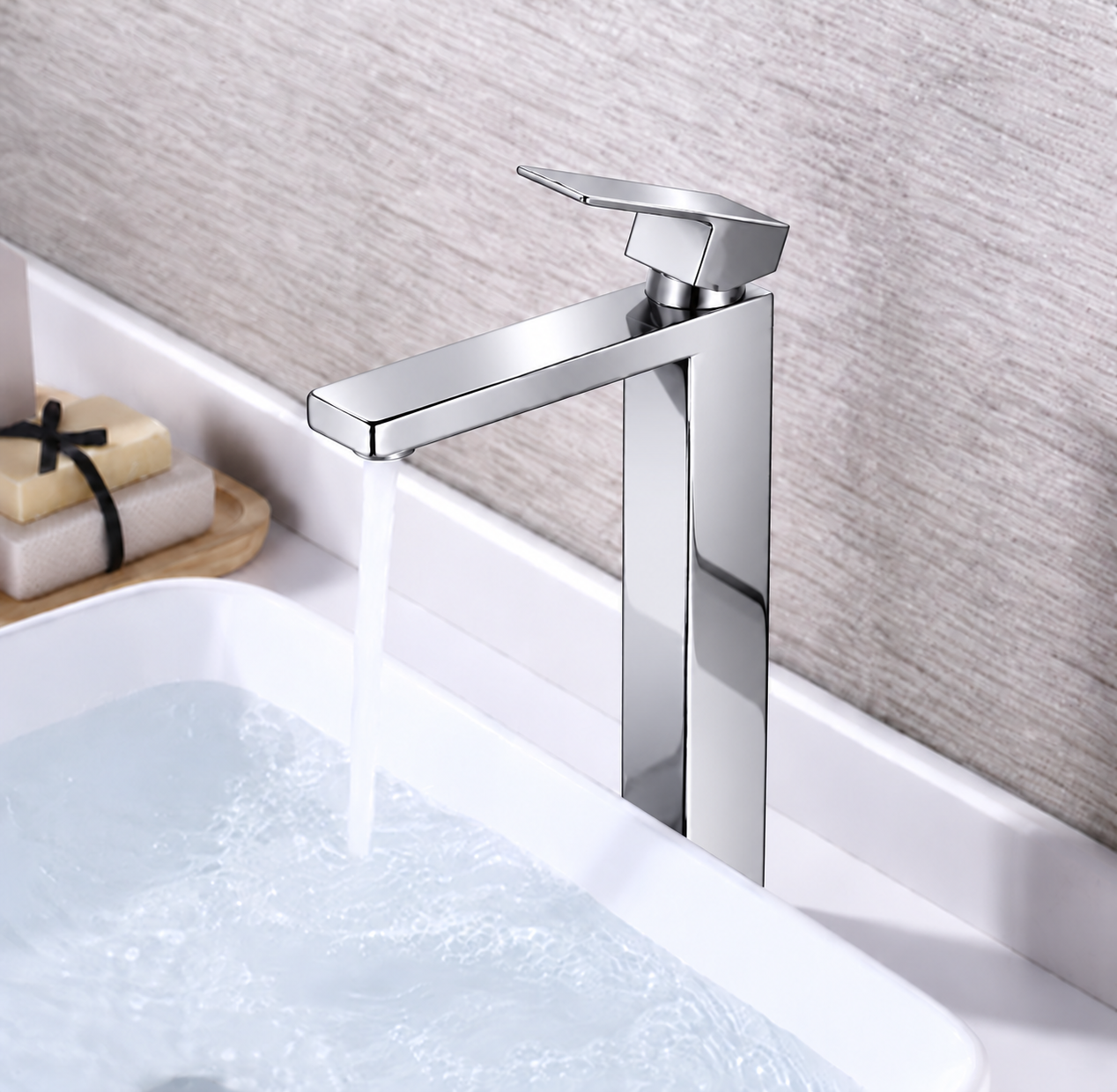 A modern single-handle bathroom faucet with a polished chrome finish, shown with water running into a white sink against a textured light gray wall.
