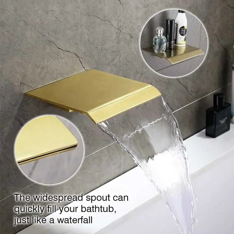 Gold faucet with water flowing into a bathtub, set against a gray tiled wall.
