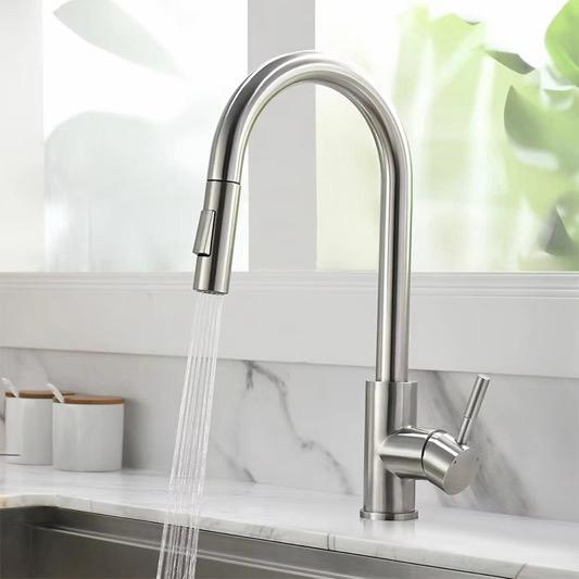 Brushed nickel kitchen faucet with pull-out spray head in use over sink