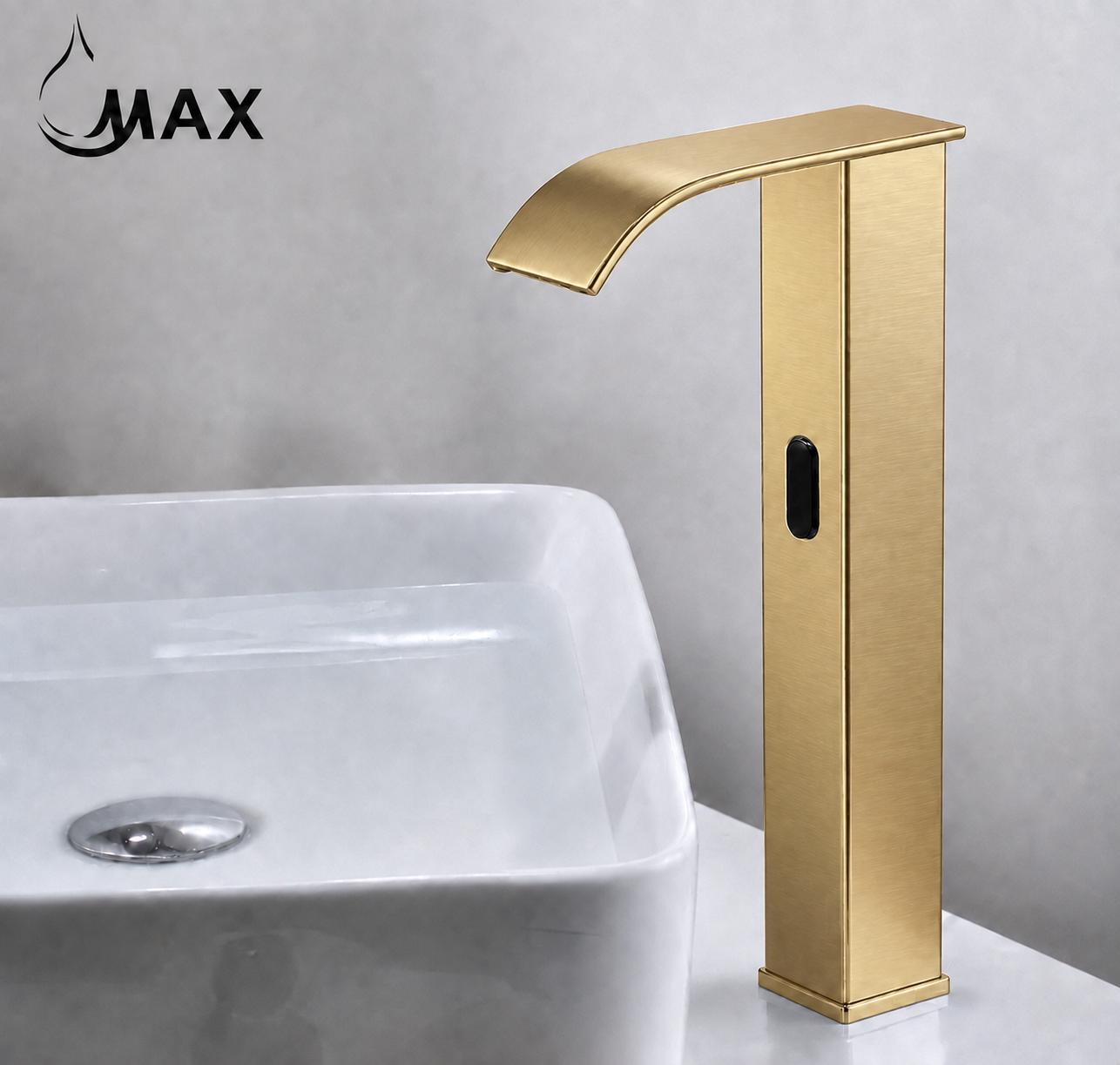 A modern tall faucet in brushed gold metal shown next to a white vessel sink. The faucet has a curved spout, a vertical body with a small black oval detail, and is set against a gray wall background.