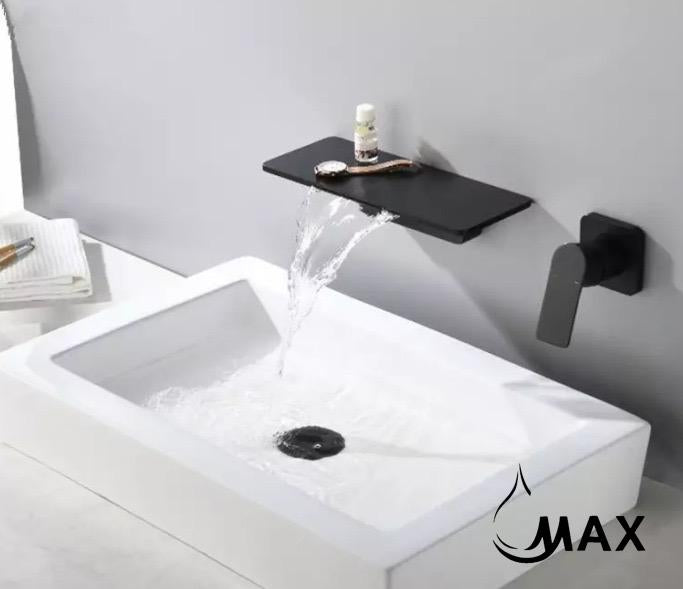 Matte black wall mount faucet with waterfall spout installed on modern bathroom sink